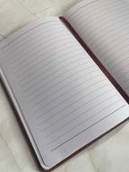 Open personalised notebook showing lined pages and ribbon bookmark, clean writing journal interior