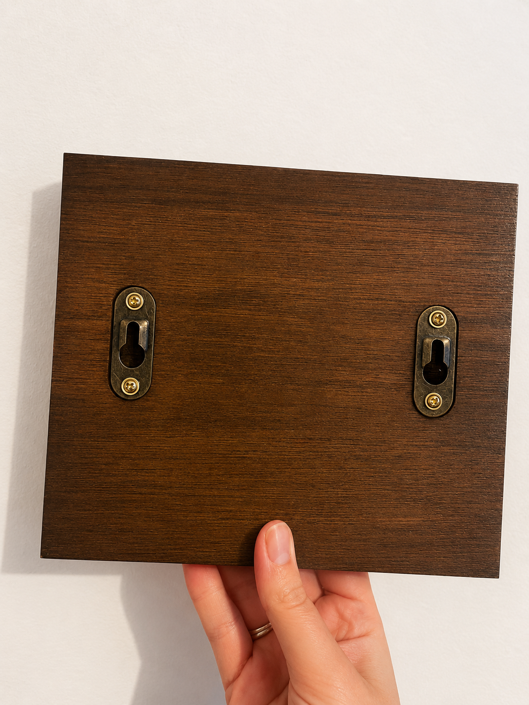 Back side of dog lead holder, showing dark wood stain with keyhole fixtures.