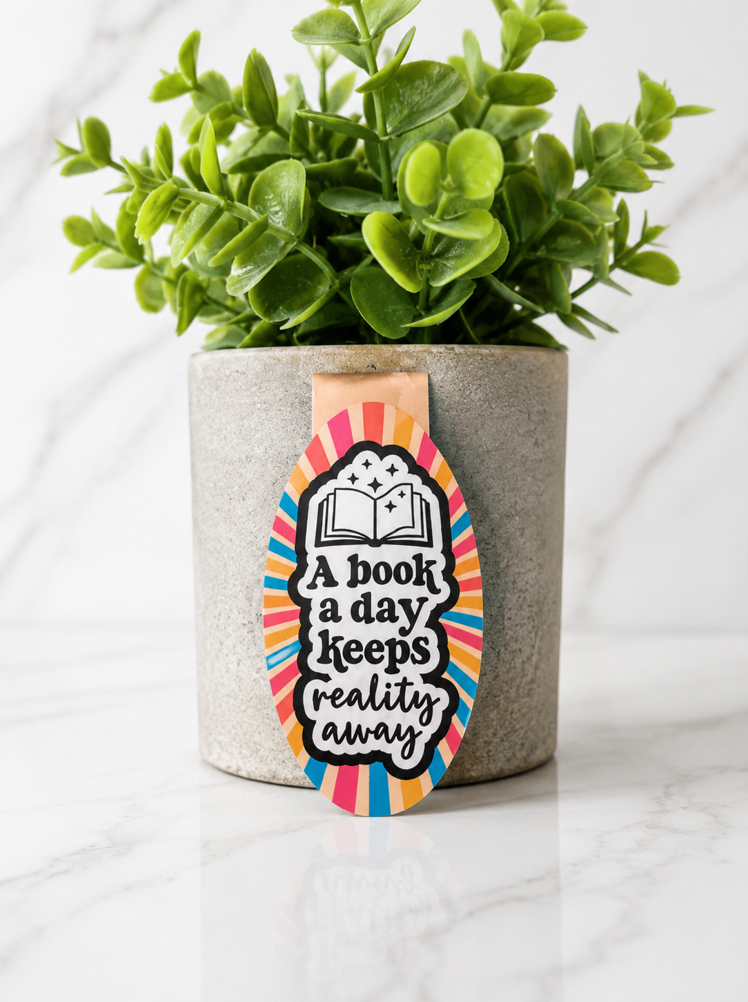 Magnetic bookmark with colourful design and quote “A book a day keeps reality away”