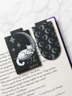 Moon cat magnetic bookmark and matching patterned bookmark placed inside an open book