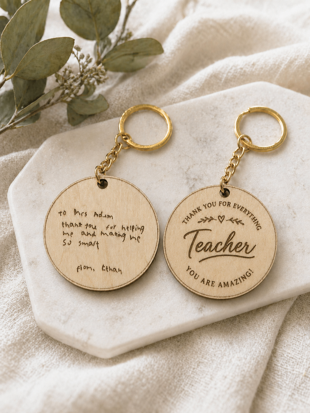 Personalised wooden teacher keychain displayed on neutral fabric background as a thoughtful thank you gift