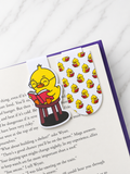 Two magnetic bookmarks with chick reading design placed inside an open book