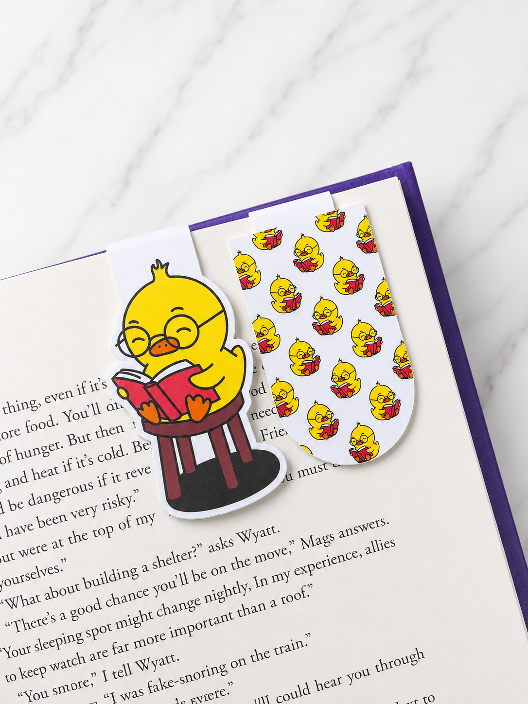 Two magnetic bookmarks with chick reading design placed inside an open book