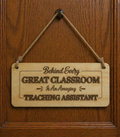 Wooden teaching assistant sign hanging on door with engraved quote about great classrooms and amazing teaching assistants