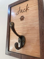 Wooden plaque with metal hook and engraved paw print, featuring the name 'Jack'.
