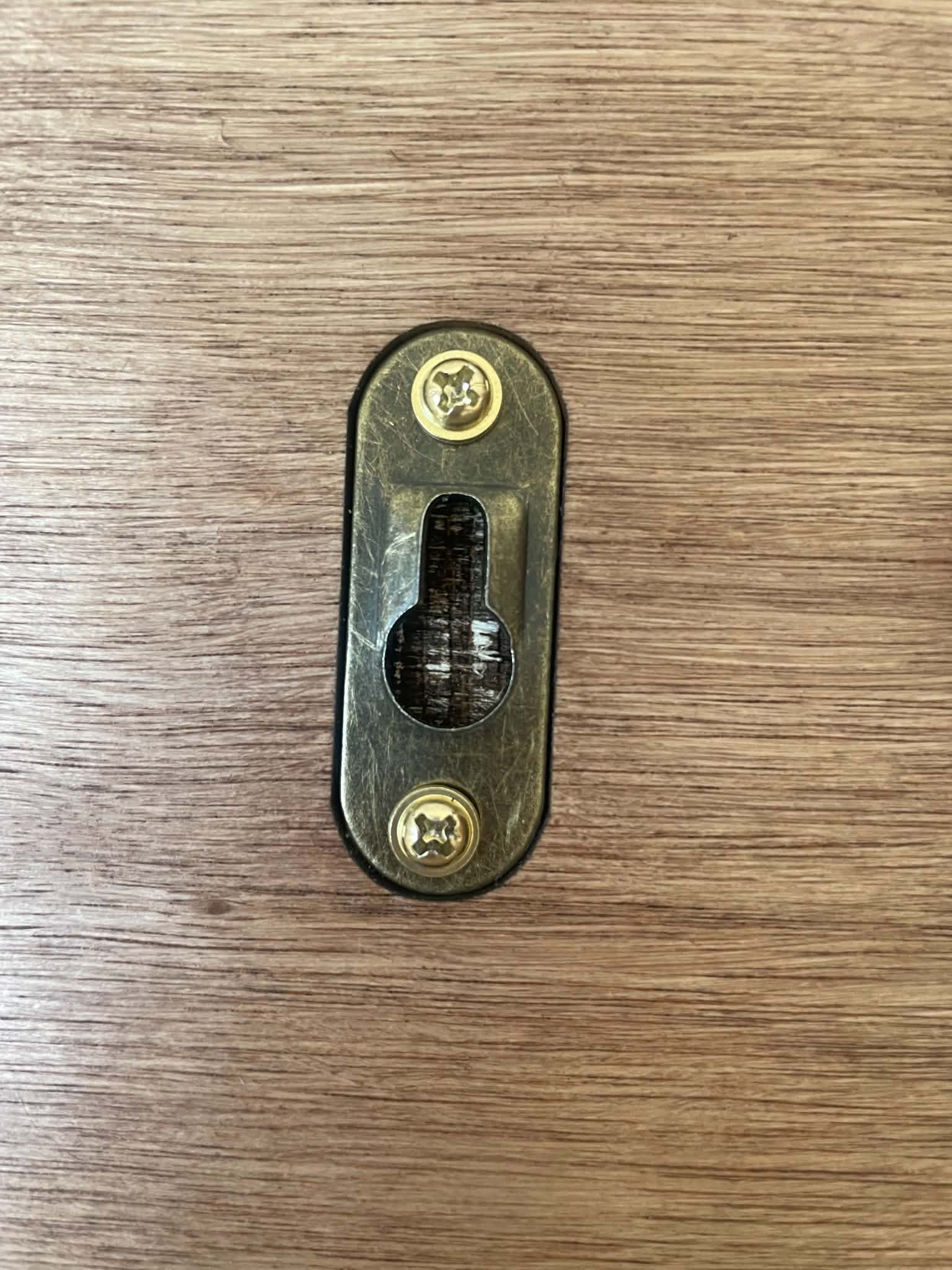 Small metal lock mechanism on a wooden surface