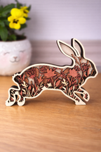 Wooden rabbit decoration with pastel red florals layered within the silhouette.  