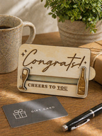 Wooden congratulations gift card holder displayed on desk with coffee mug and gift card