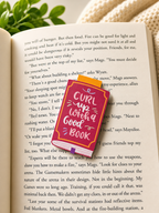 Magnetic bookmark on open book with warm cosy lighting and blanket background