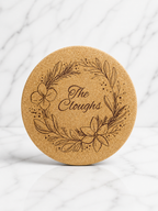 Round cork trivet engraved with floral wreath and personalised family name in centre