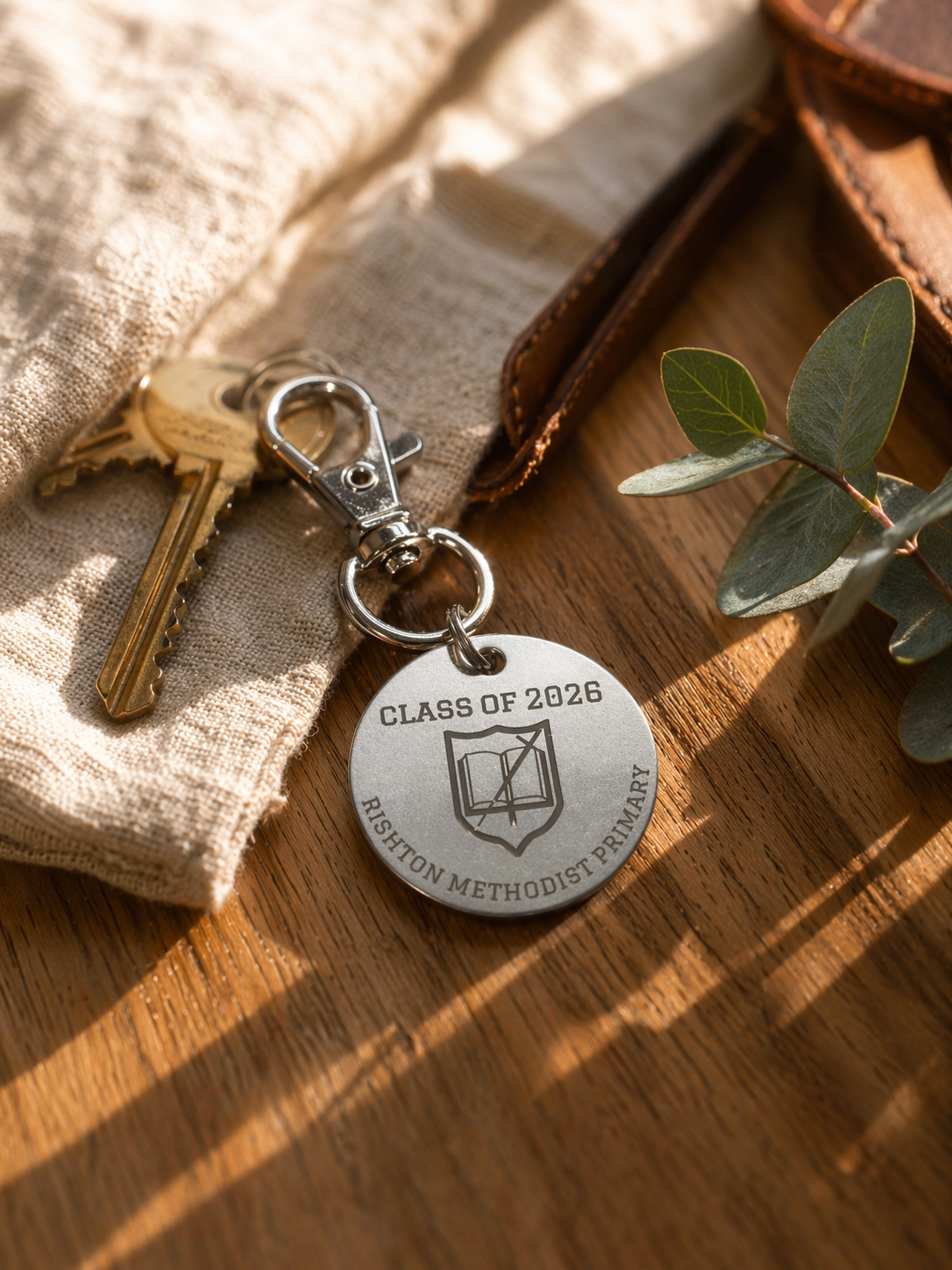Personalised Class of 2026 keychain on wooden surface with keys, fabric and greenery, lifestyle product image