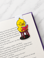 Magnetic bookmark featuring a chick reading a book clipped onto a page