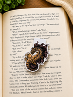 Fantasy dragon magnetic bookmark placed inside an open book on a wooden surface