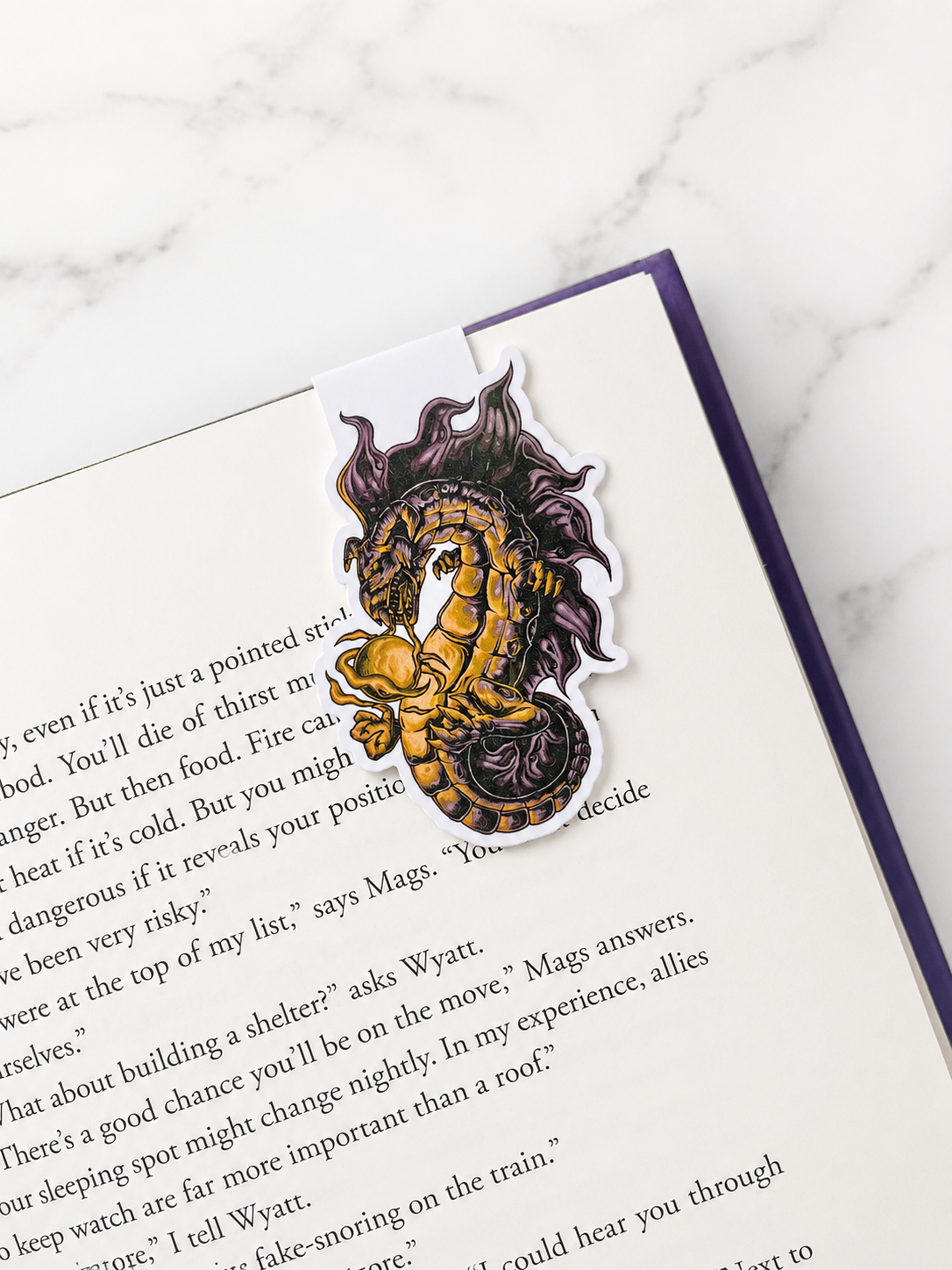 Magnetic bookmark with fantasy dragon  design clipped onto a book page