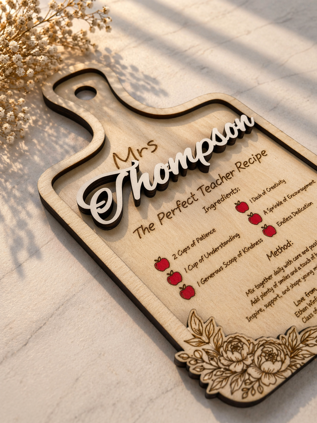 Close up of engraved wooden teacher plaque with floral border and personalised name detail