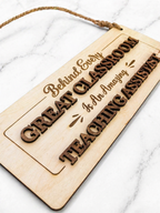 Close up of engraved wooden teaching assistant sign showing layered lettering and detailed engraving design