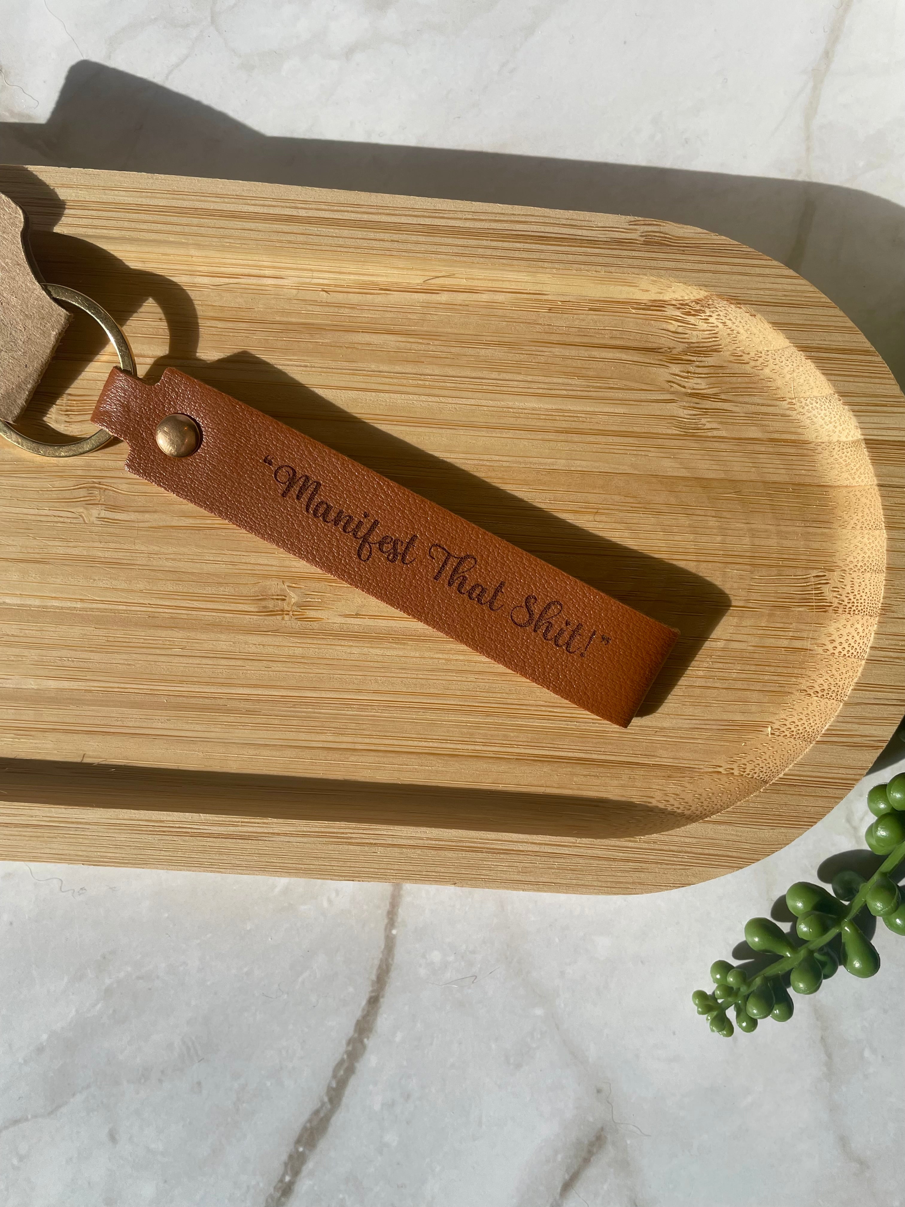 “Manifest That Shit” Engraved Faux Leather Keychain – Motivational Keyring