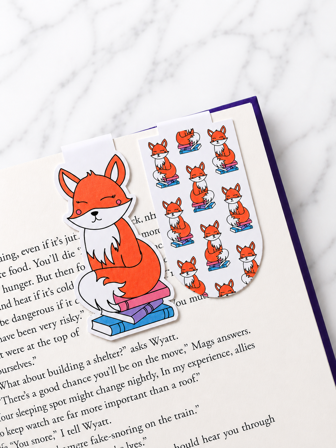Two fox magnetic bookmarks clipped onto book pages showing both character and pattern designs in use