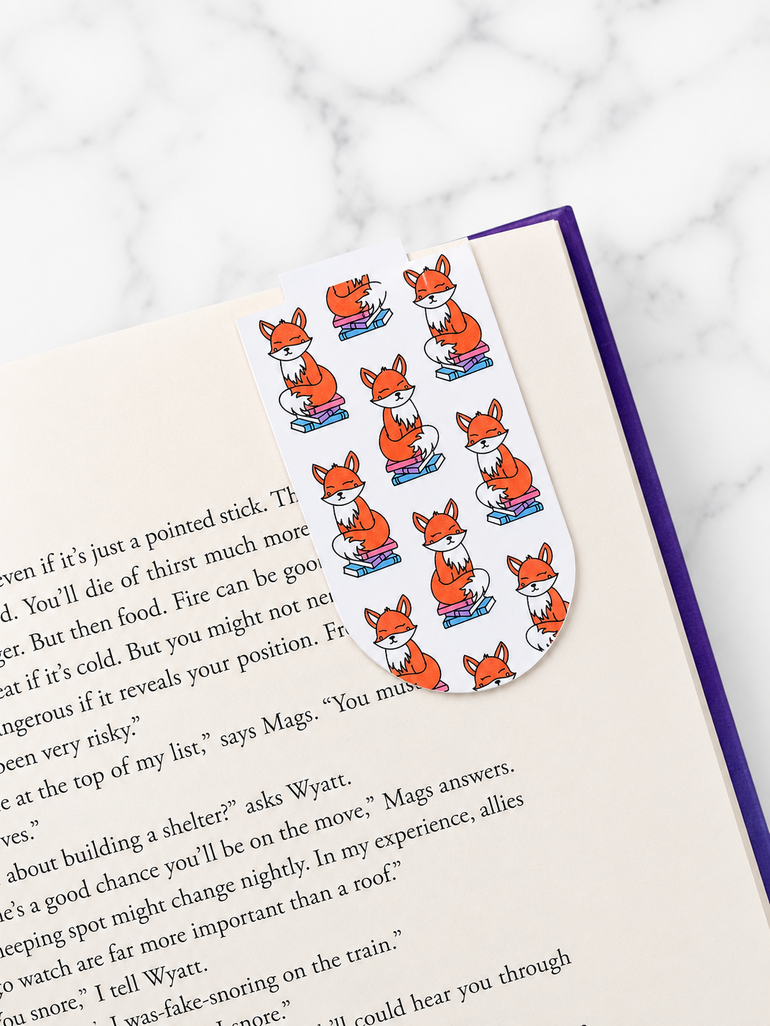 Magnetic bookmark with fox pattern clipped onto a book page showing how it holds place securely