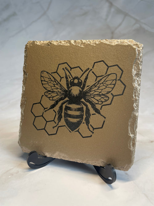 Gold painted slate with an engraved bee and honeycomb design.