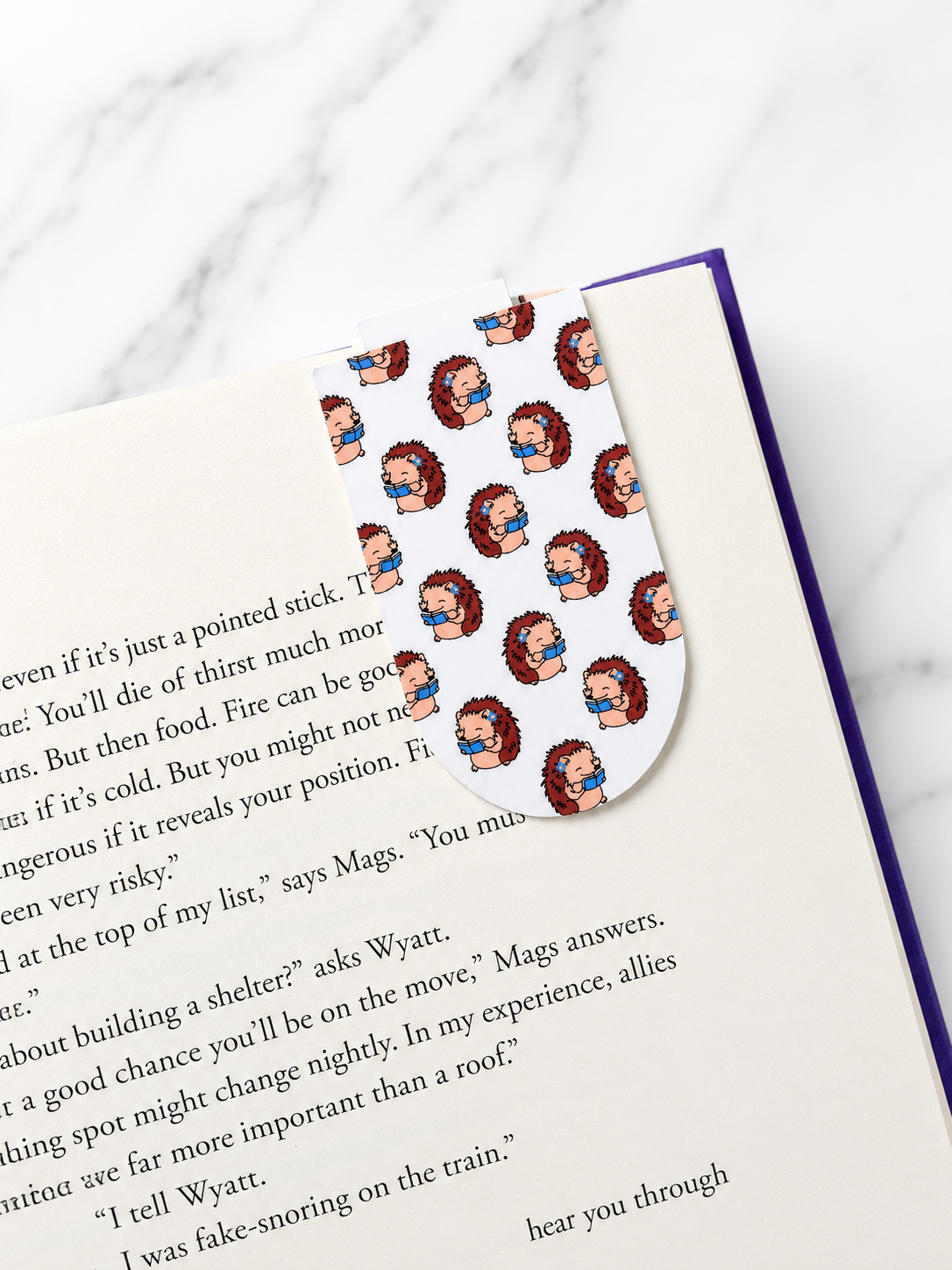 Magnetic bookmark with hedgehog pattern clipped onto a book page showing how it holds place securely