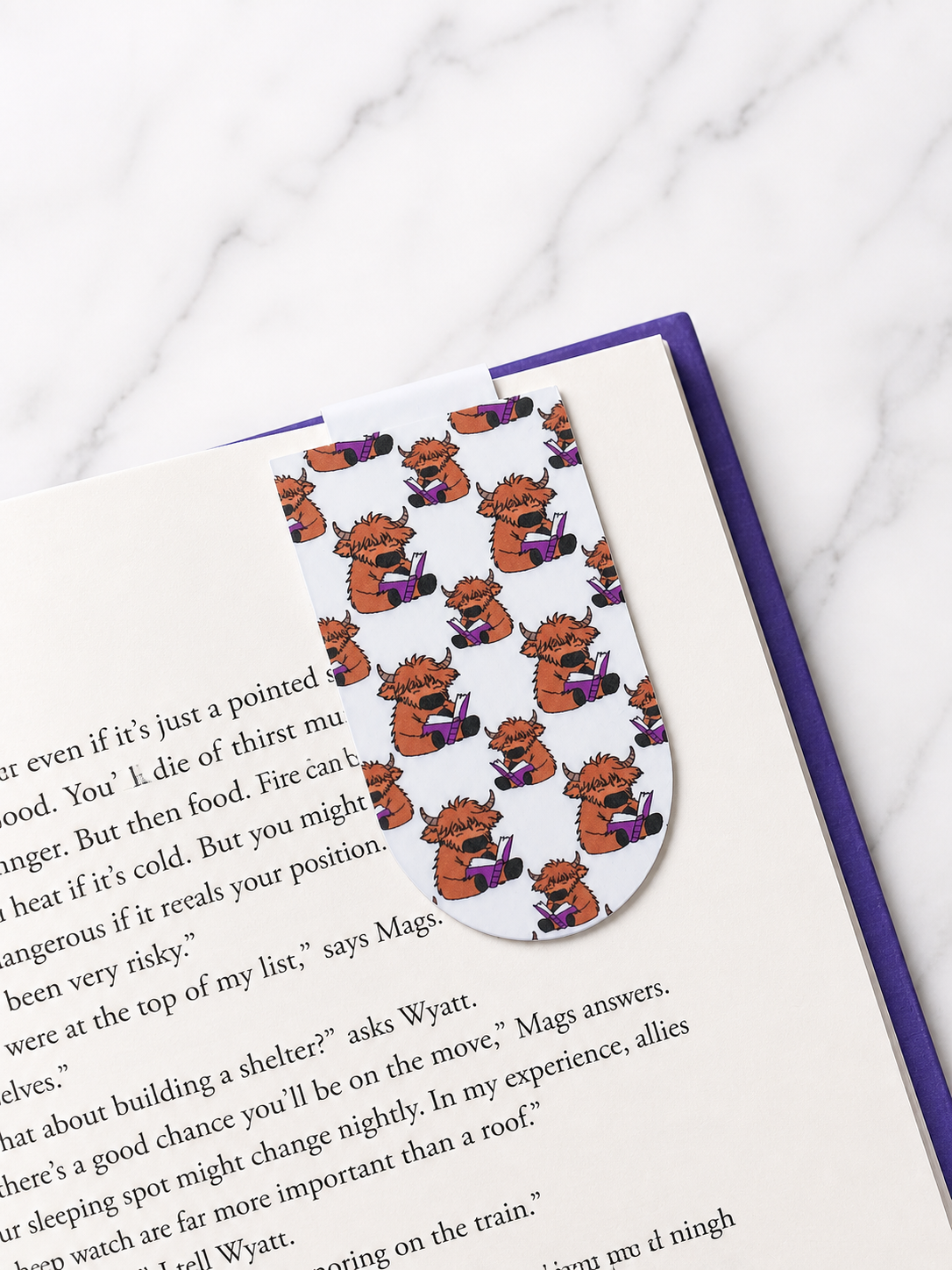 Pattern Highland cow magnetic bookmark clipped onto a book page demonstrating practical use and secure page marking