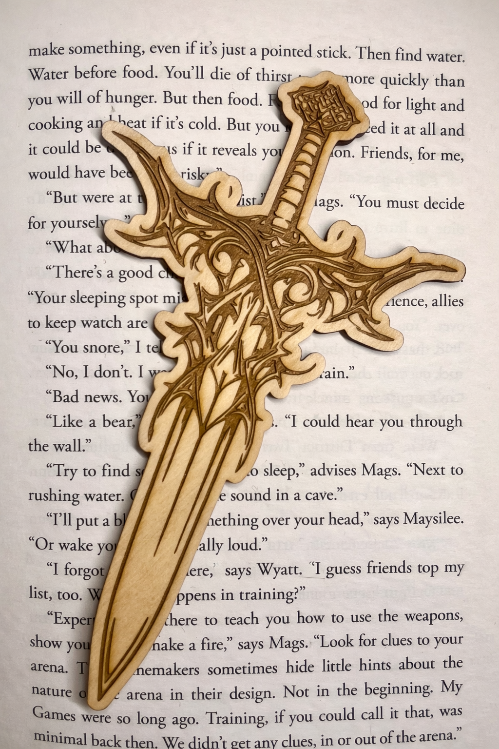Laser engraved sword bookmark placed on book for reading accessory