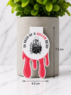 Dripping blood style magnetic bookmark with skeleton reading design and quote “In need of a killer read”, shown with size measurements 7.3 cm by 4.2 cm against a neutral plant and marble background