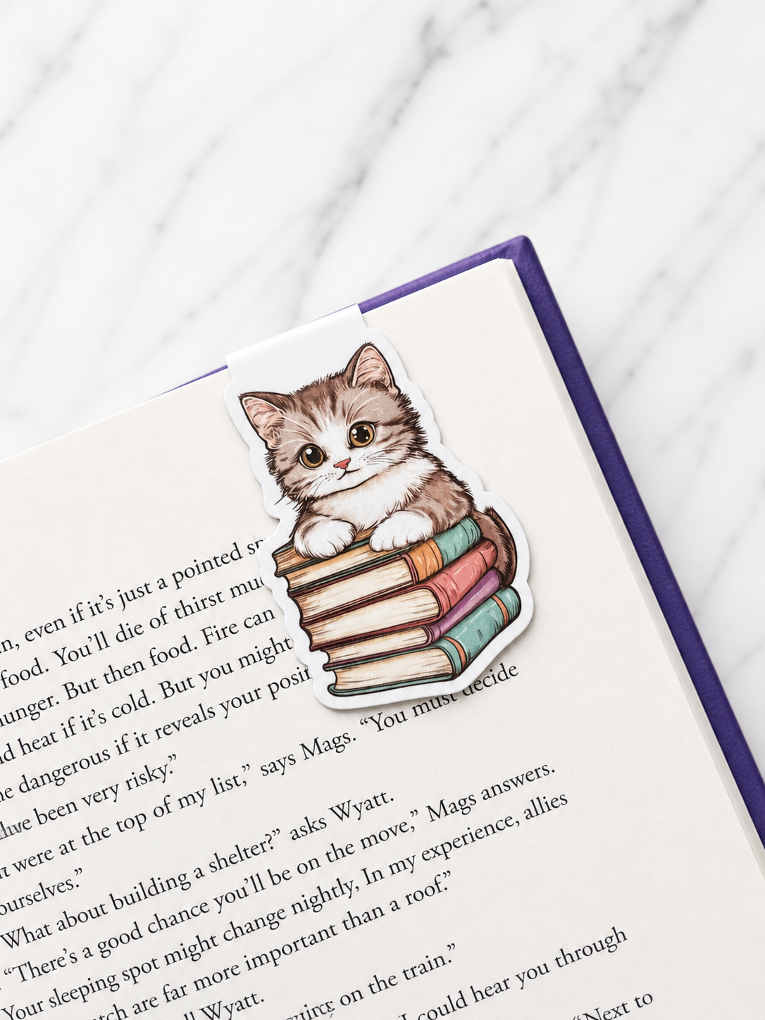 Kitten bookmark clipped onto book page showing secure hold