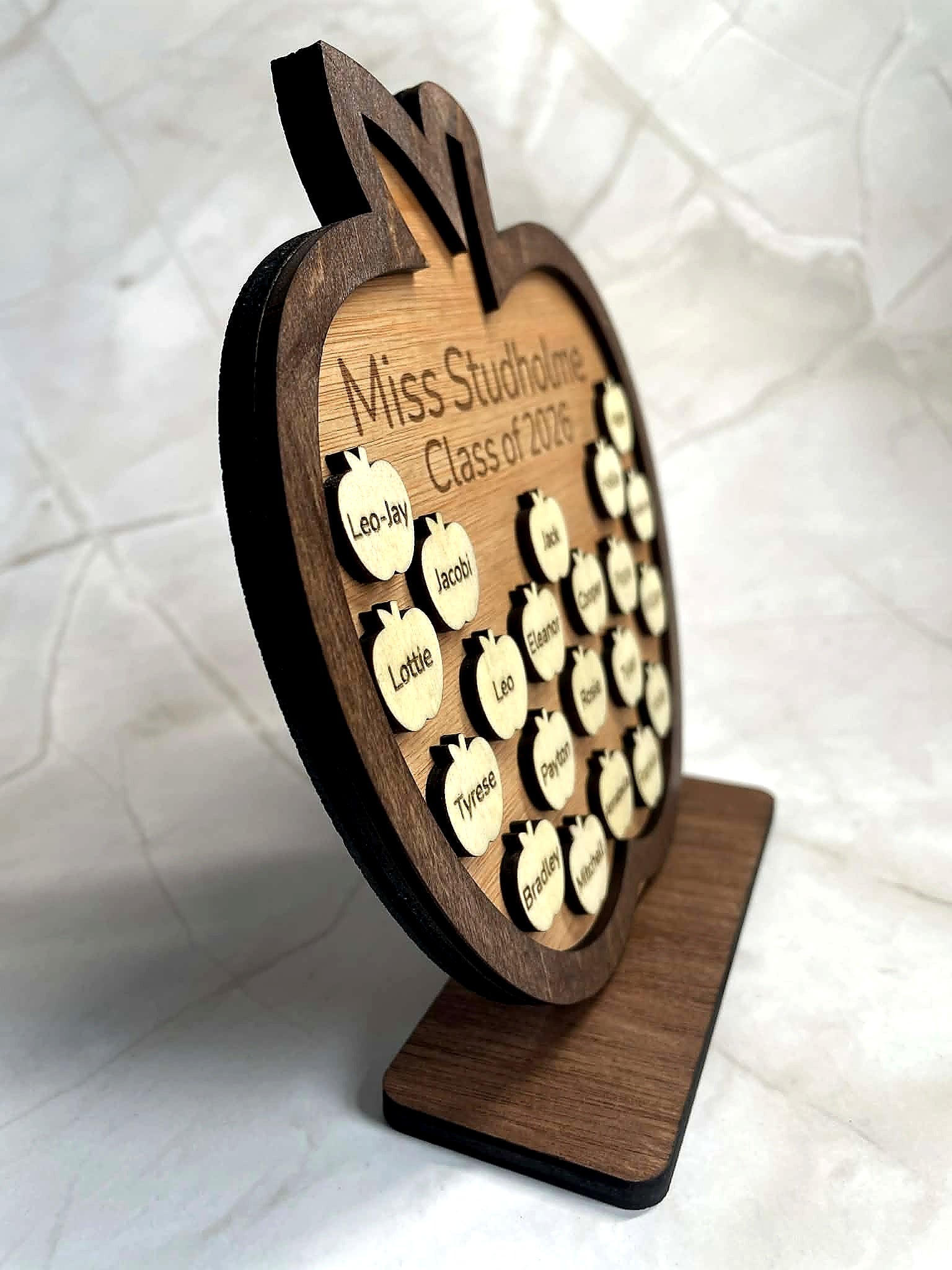 Side view of layered wooden apple plaque showing depth and raised student name pieces on engraved teacher gift