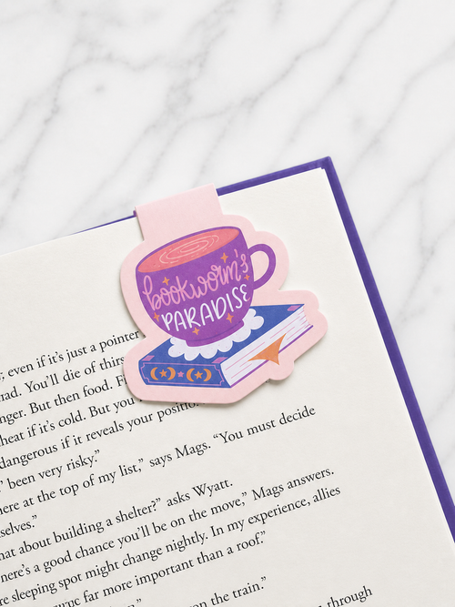 Pink and purple magnetic bookmark clipped onto book page showing secure hold and cosy reading aesthetic