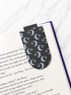 Magnetic bookmark with moon and star pattern clipped onto a book page