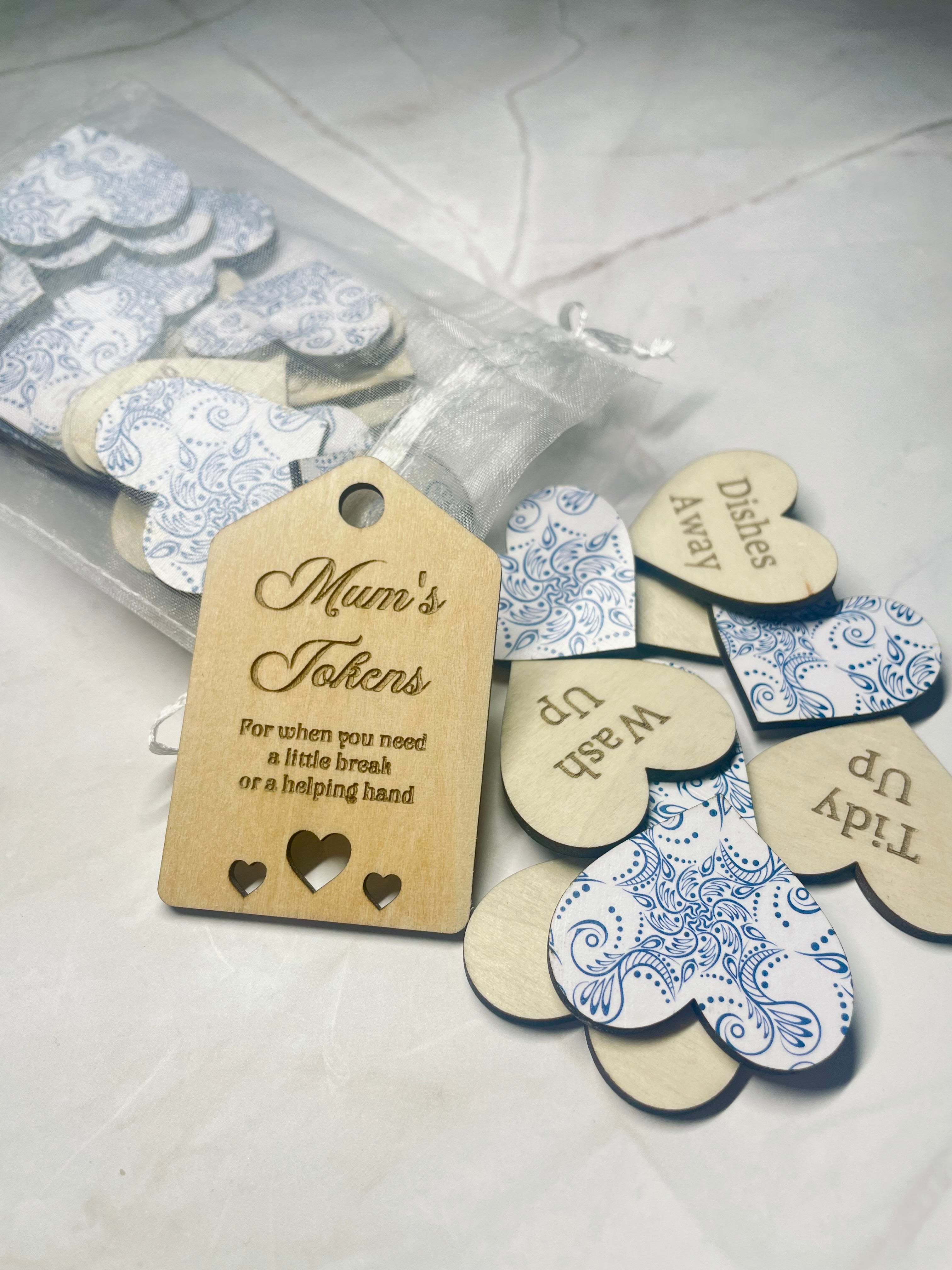 Heart-shaped tokens with decorative patterns and a wooden tag labeled 'Mum's Tokens' on a light background.