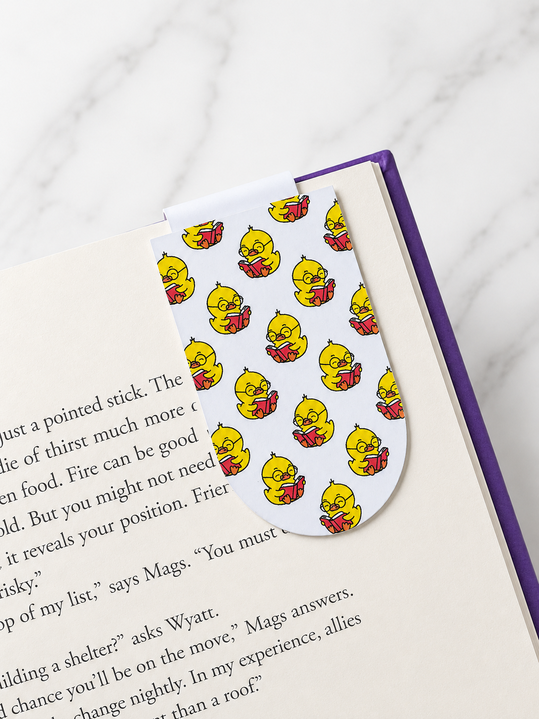 Magnetic bookmark with repeating chick reading pattern clipped onto a book page