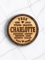 Wooden engraved coaster featuring the name Charlotte and positive traits, personalised gift idea displayed on marble