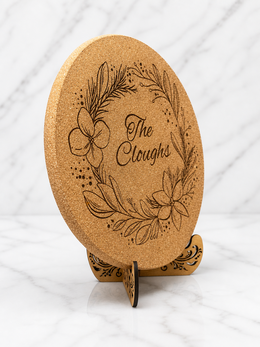 Close up angled view of engraved cork trivet showing detailed floral wreath design