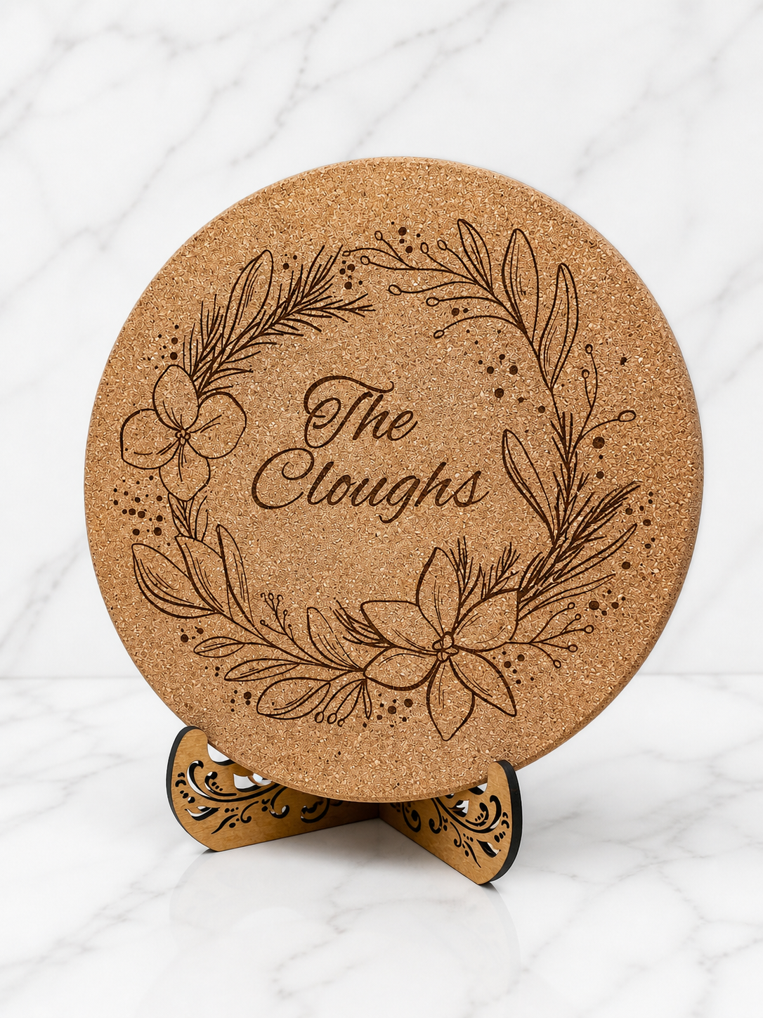 Engraved cork trivet displayed upright on wooden stand as kitchen decor