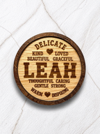 Close-up of engraved wooden coaster with the name Leah and positive descriptive words, personalised name meaning gift