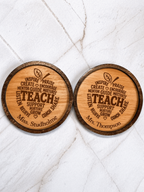 Two personalised engraved wooden teacher coasters side by side featuring different custom names on a marble background