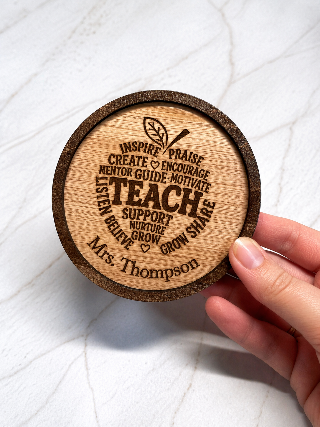 Hand holding personalised engraved wooden teacher coaster showing size and detail of custom name and inspirational text