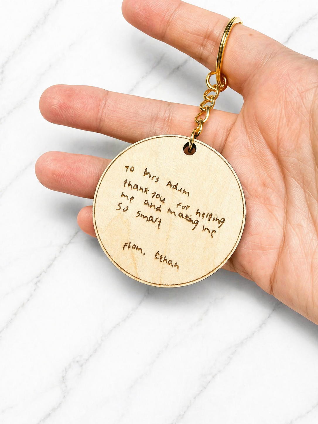 Personalised teaching assistant keyring with custom engraved message on back held in hand