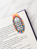 Colourful magnetic bookmark with reading quote clipped onto a book page