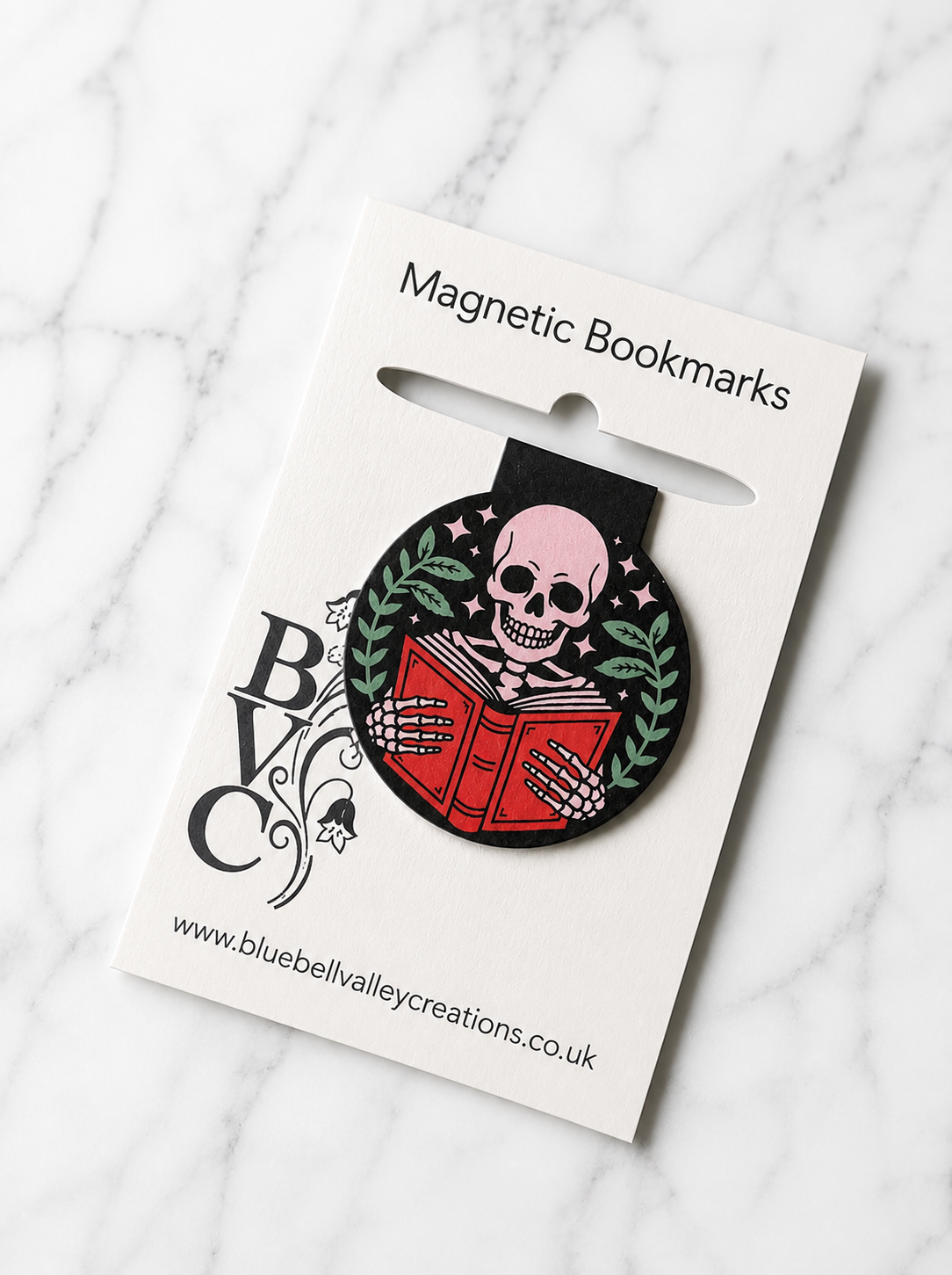 Skeleton reading magnetic bookmark displayed on Bluebell Valley Creations branded packaging on a marble background