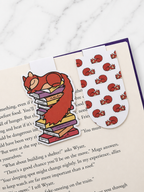 Two magnetic bookmarks featuring a sleeping squirrel clipped onto book pages showing both designs in use