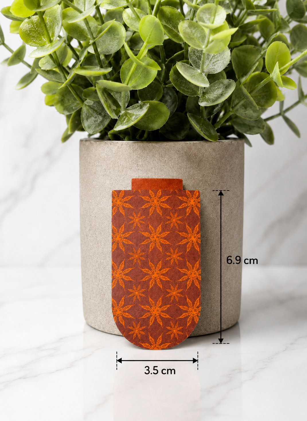 Magnetic bookmark with sun pattern design shown with measurements 6.9 cm by 3.5 cm