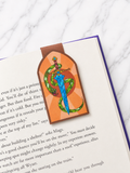Magnetic bookmark with sword and snake design clipped onto an open book showing how it marks pages