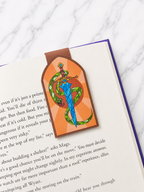 Magnetic bookmark with sword and snake design clipped onto an open book showing how it marks pages