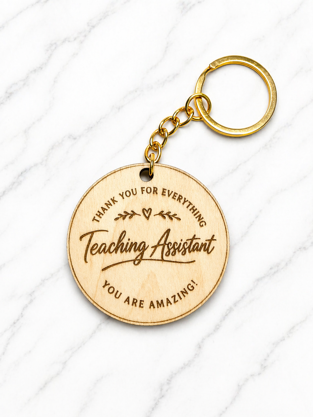 Teaching assistant thank you keyring engraved wooden disc with gold keychain on marble background