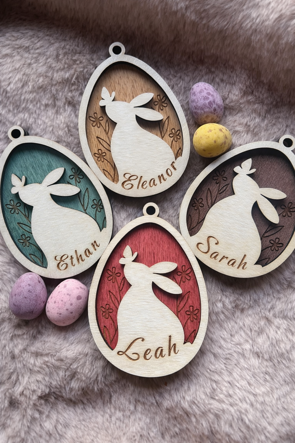 Wooden Easter tag with a bunny and butterfly inside an egg wit ha floral stained background. There are 4 tags with different colours and names.