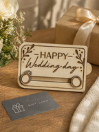 Wooden wedding gift card holder displayed with wrapped gift box and flowers as a wedding present idea